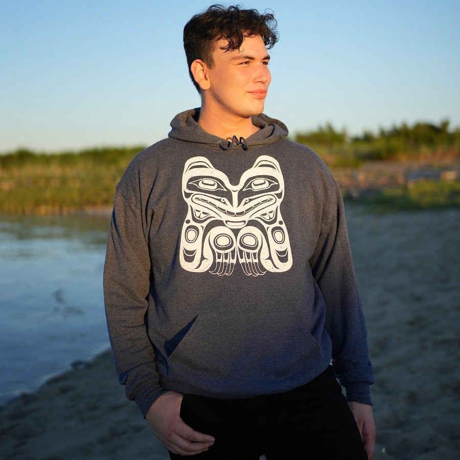 Model wearing unisex hoodie featuring a bear by indigenous artist
