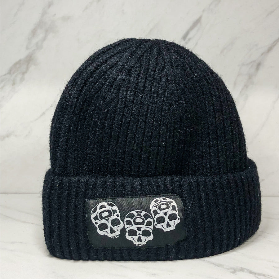 Black wool winter hat with embroidered skull design by Haida artist Jesse Brillon