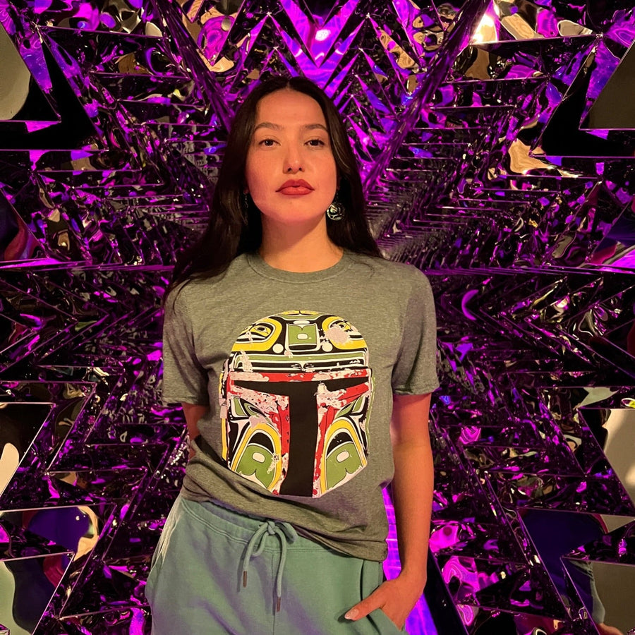 Female model wearing Resilience Unisex T-Shirt by indigenous artist Andy Everson
