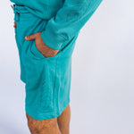 Side view of Model wearing Organic cotton shorts in teal by indigenous artist