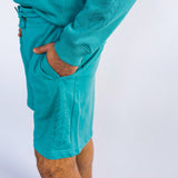 Side view of Model wearing Organic cotton shorts in teal by indigenous artist