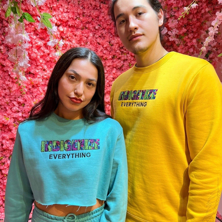Two models wearing Indigenize everything sweatshirt by indigenous artist