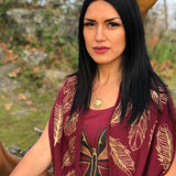Model wearing infinity scarf by indigenous artist leaf pattern in maroon