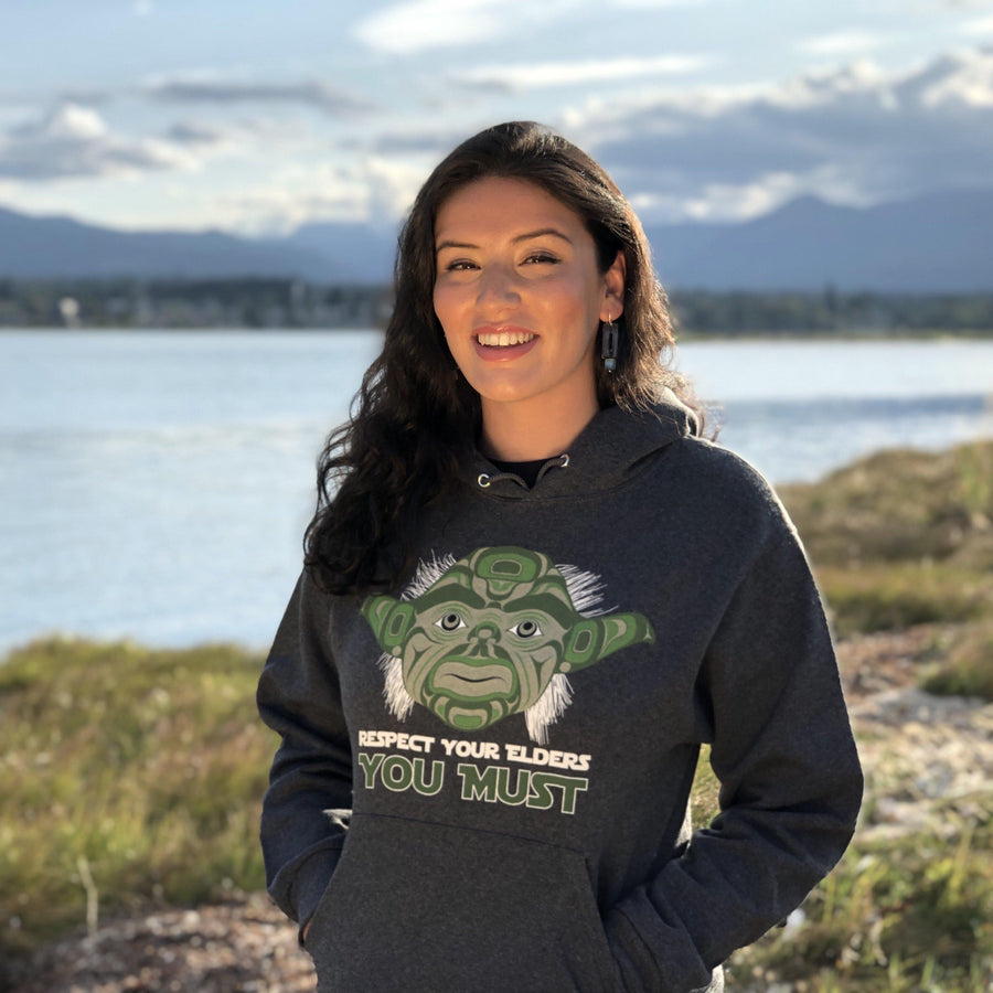 Model outside wearing unisex hoodie called elder by indigenous artist