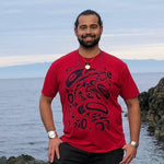 Model wearing unisex t-shirt raven and eagle motif by indigenous artist in red