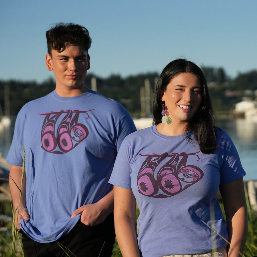 Models outside wearing unisex t-shirt featuring a sloth by indigenous artist