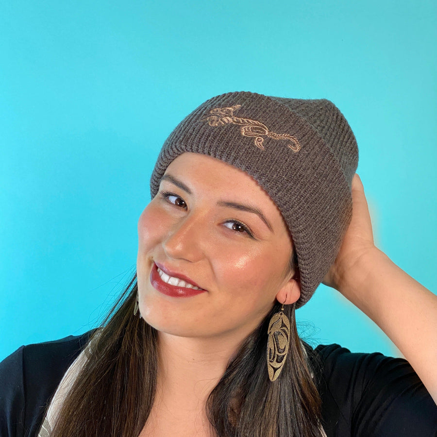 Model wearing brown wool winter hat with embroidered Wolf design by Haida artist Jesse Brillon