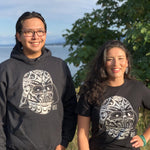 Two models wearing Unisex apparel called Rise by indigenous artist Andy Everson