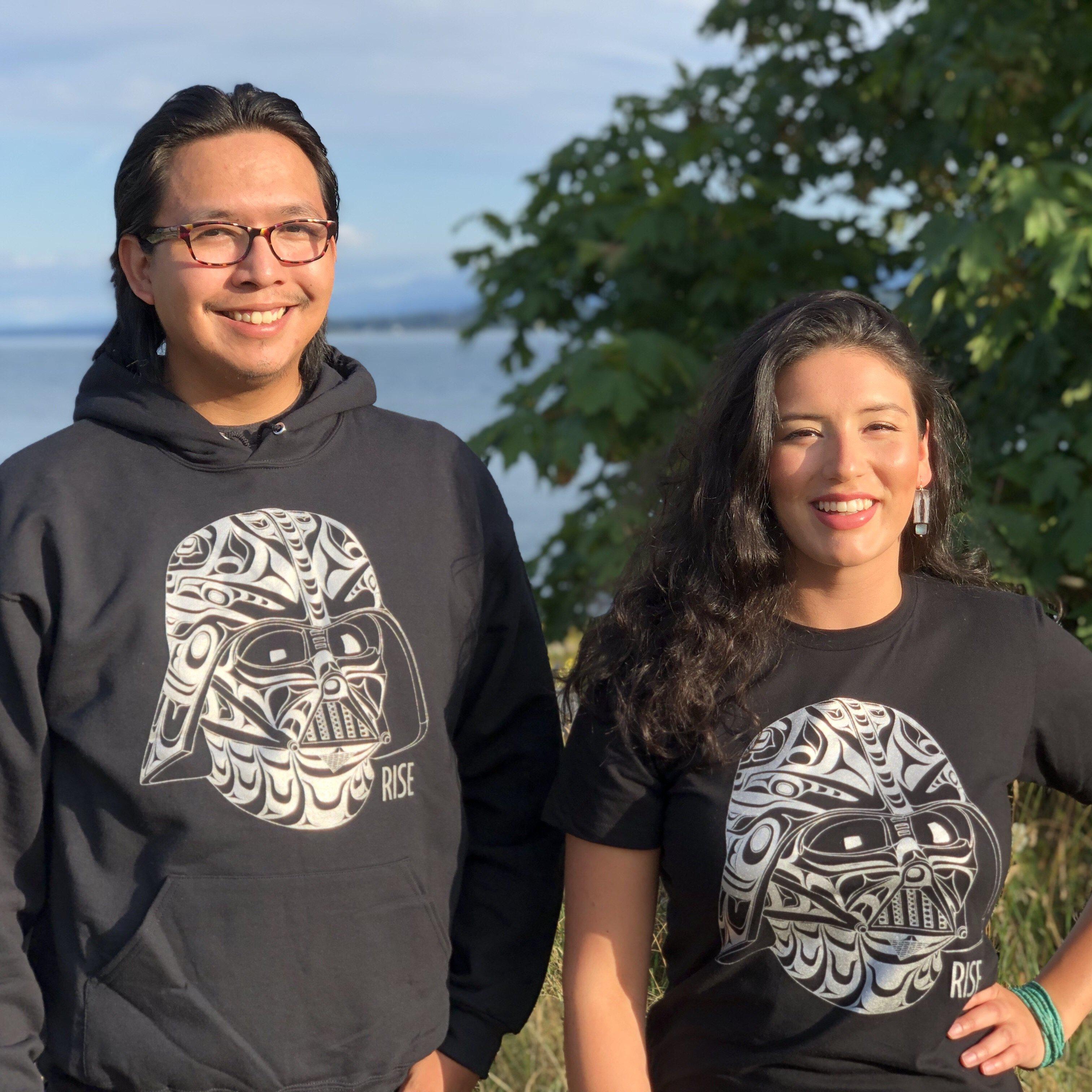 Two models wearing Unisex apparel called Rise by indigenous artist Andy Everson