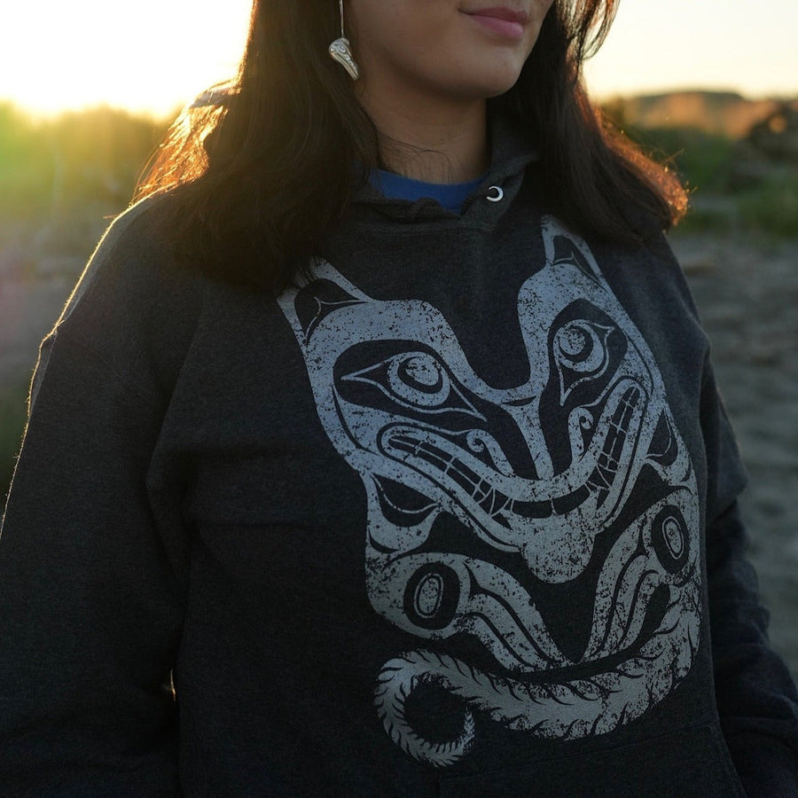 Model wearing Unisex hoodie called wolf by indigenous artist