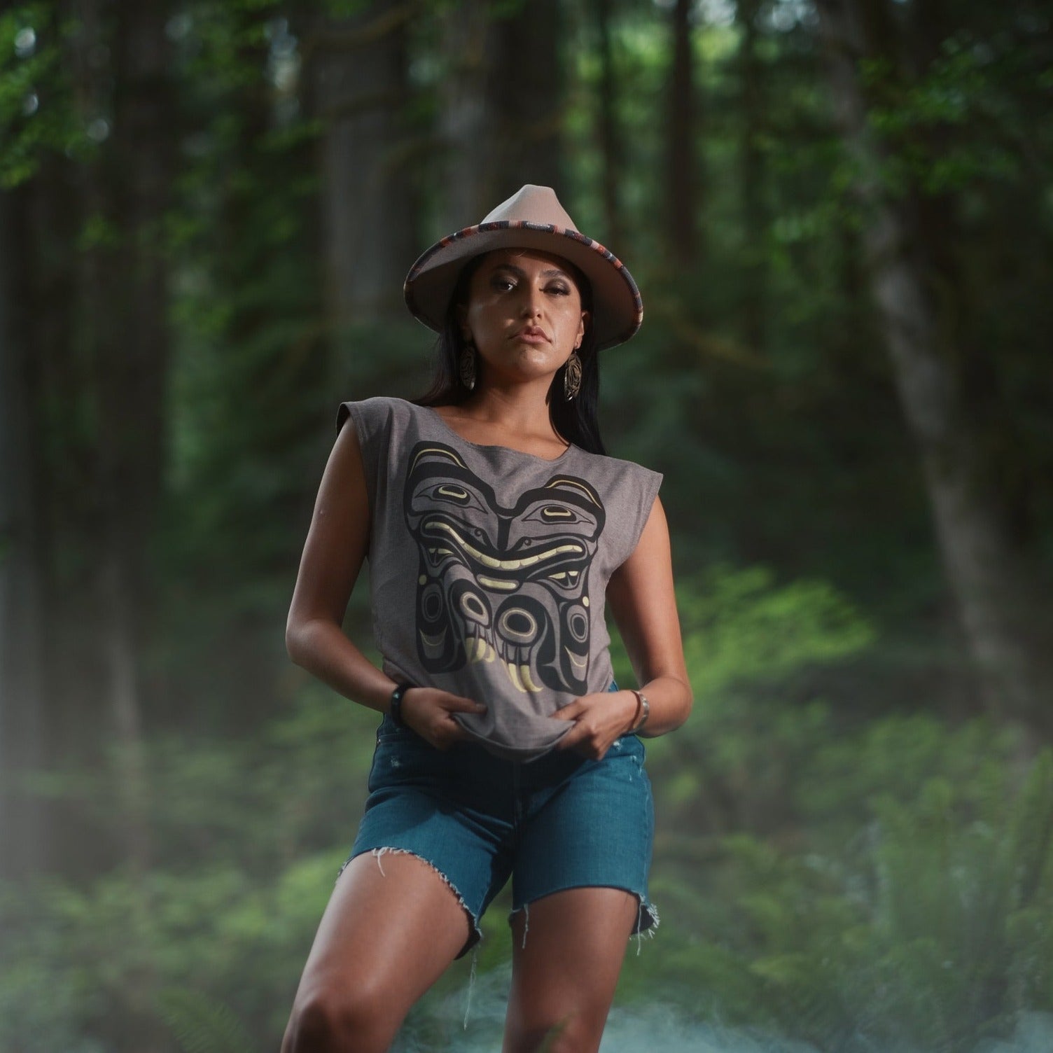 Model wearing cap-sleeve bamboo top by indigenous artist featuring a bear