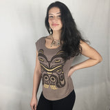 Model wearing cap-sleeve bamboo top by indigenous artist featuring a bear with hand at side