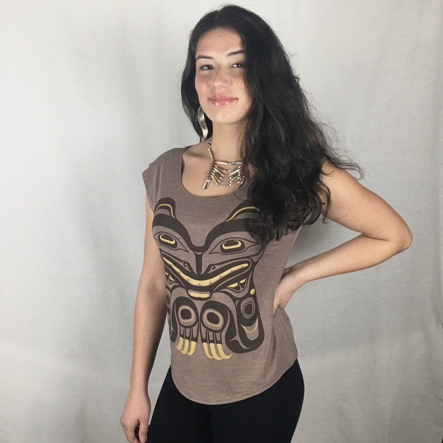 Model wearing cap-sleeve bamboo top by indigenous artist featuring a bear with hand at side