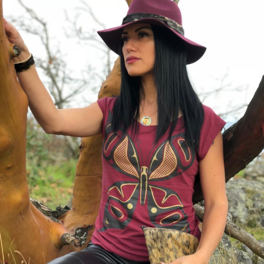 Model outside wearing cap-sleeve bamboo top by indigenous artist featuring a butterfly