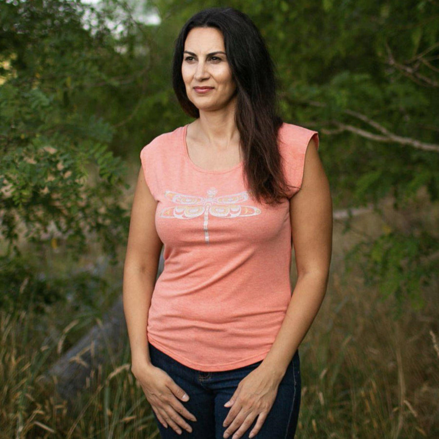 Model outside wearing womens top created by indigenous artist featuring a dragonfly