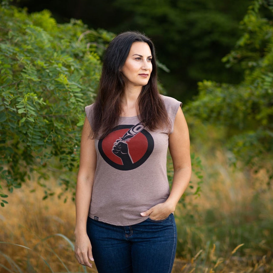 Model outside wearing womens top created by indigenous artist called idle no more