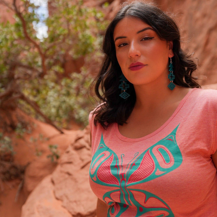 Model outside wearing womens top created by indigenous artist featuring the butterfly