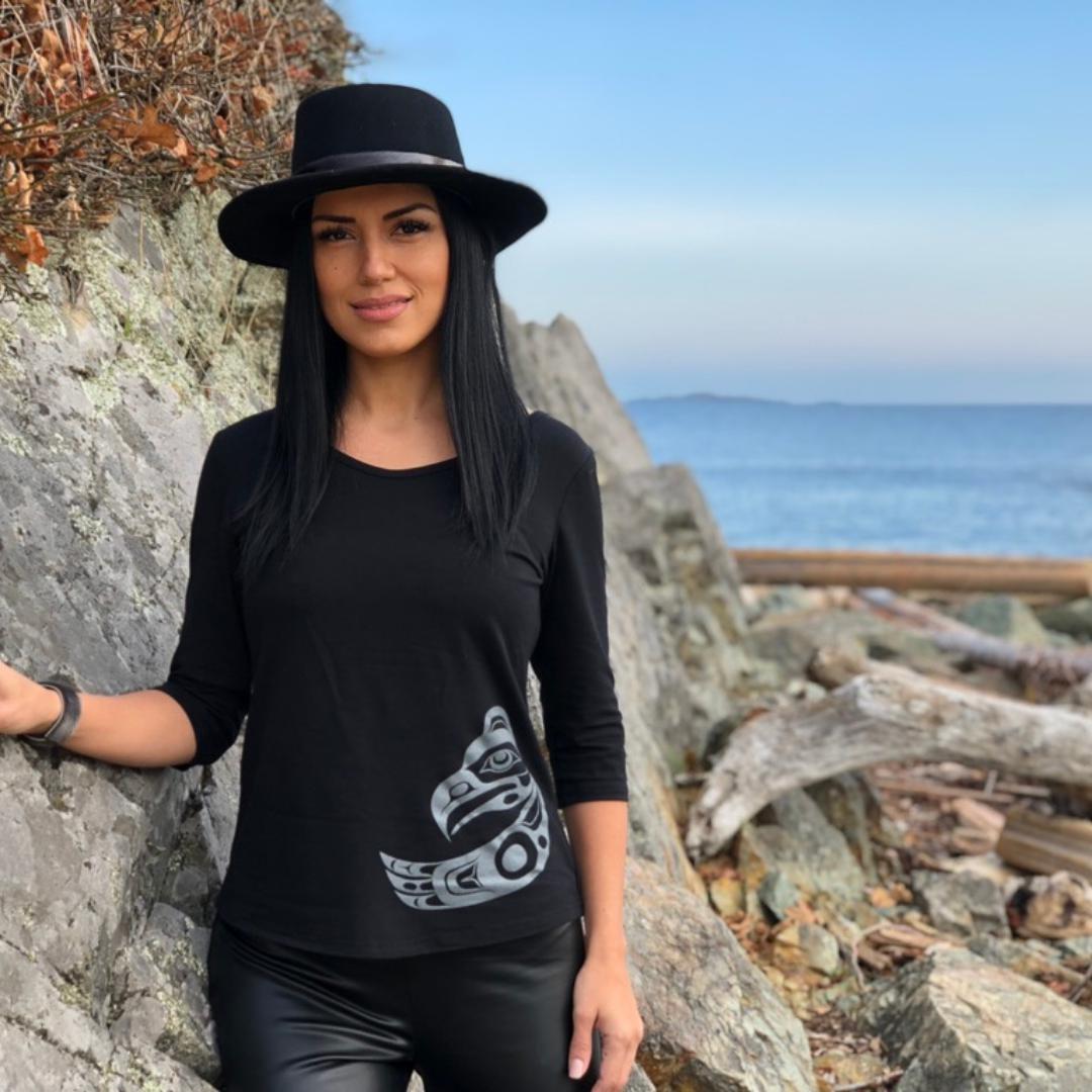 Model outside wearing womens organic cotton top by indigenous artist featuring eagle in black