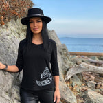 Model outside wearing womens organic cotton top by indigenous artist featuring eagle in black