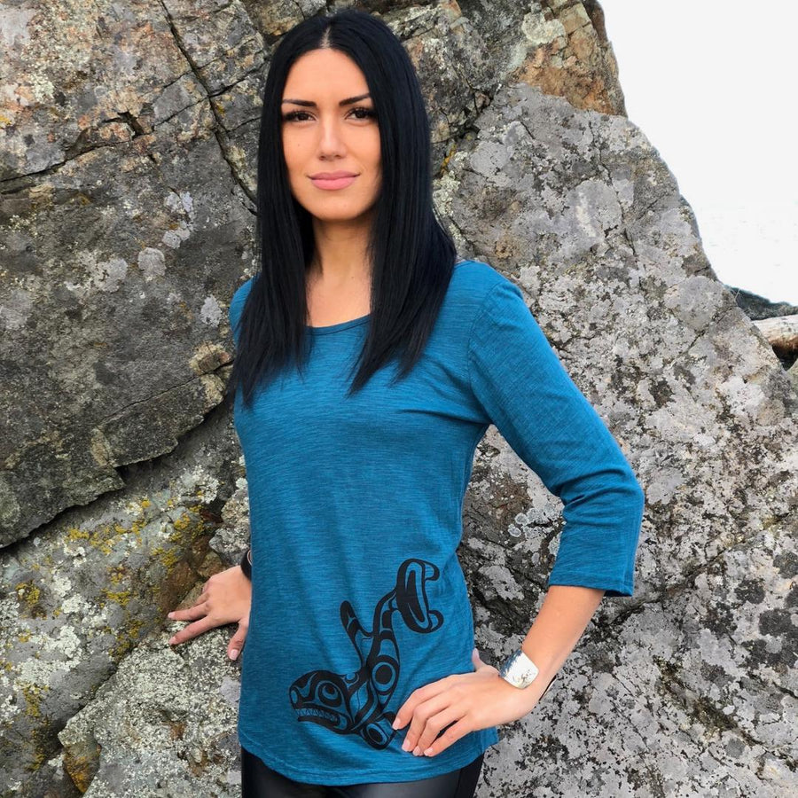 Model outside wearing womens organic cotton top by indigenous artist featuring the killer whale