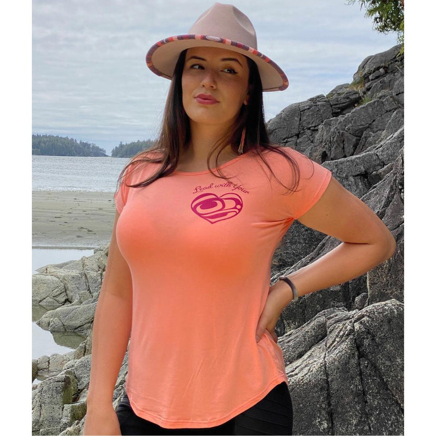 Model wearing womens top created by indigenous artist called Lead with your heart in pink