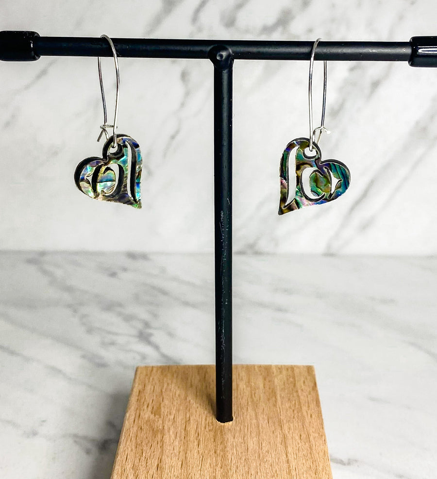 Close up up of abalone heart earrings by indigenous artist
