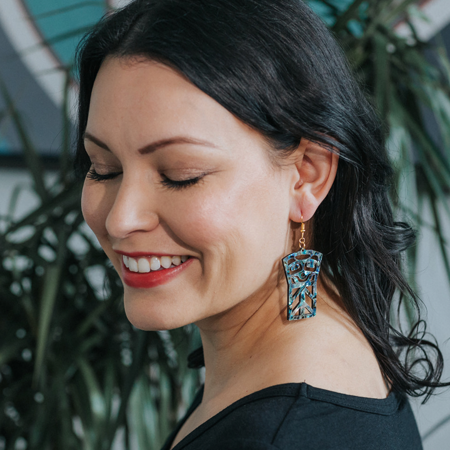 Model wearing abalone shell earrings by indigenous artist copper