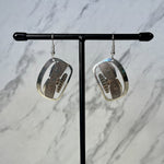 Close up up Chilkat silver earrings by indigenous artist