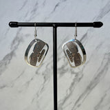 Close up up Chilkat silver earrings by indigenous artist