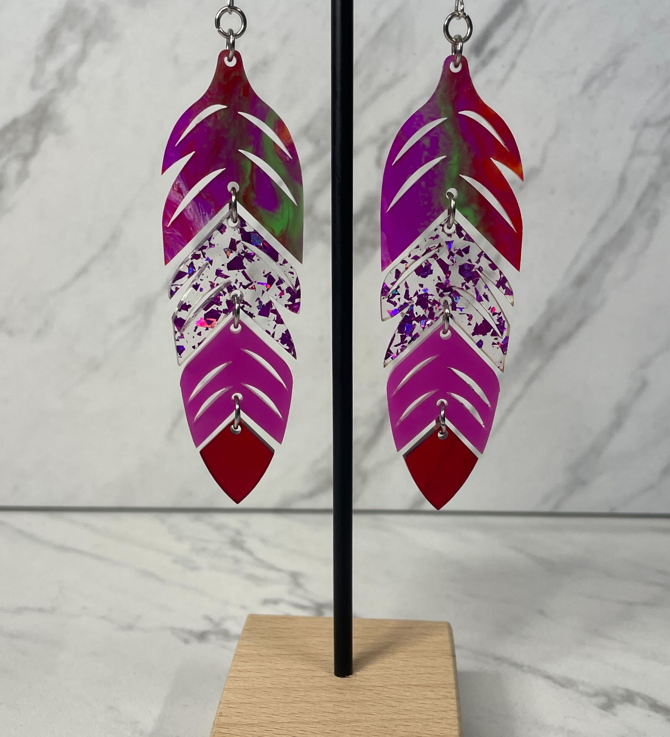 Close up up of dynamic tiered feather earrings by indigenous artist acrylic 2