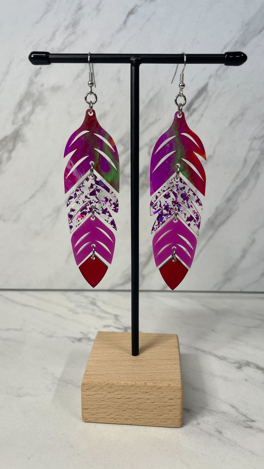 Close up up of dynamic tiered feather earrings by indigenous artist acrylic 2