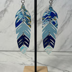 Close up up of dynamic tiered feather earrings by indigenous artist acrylic