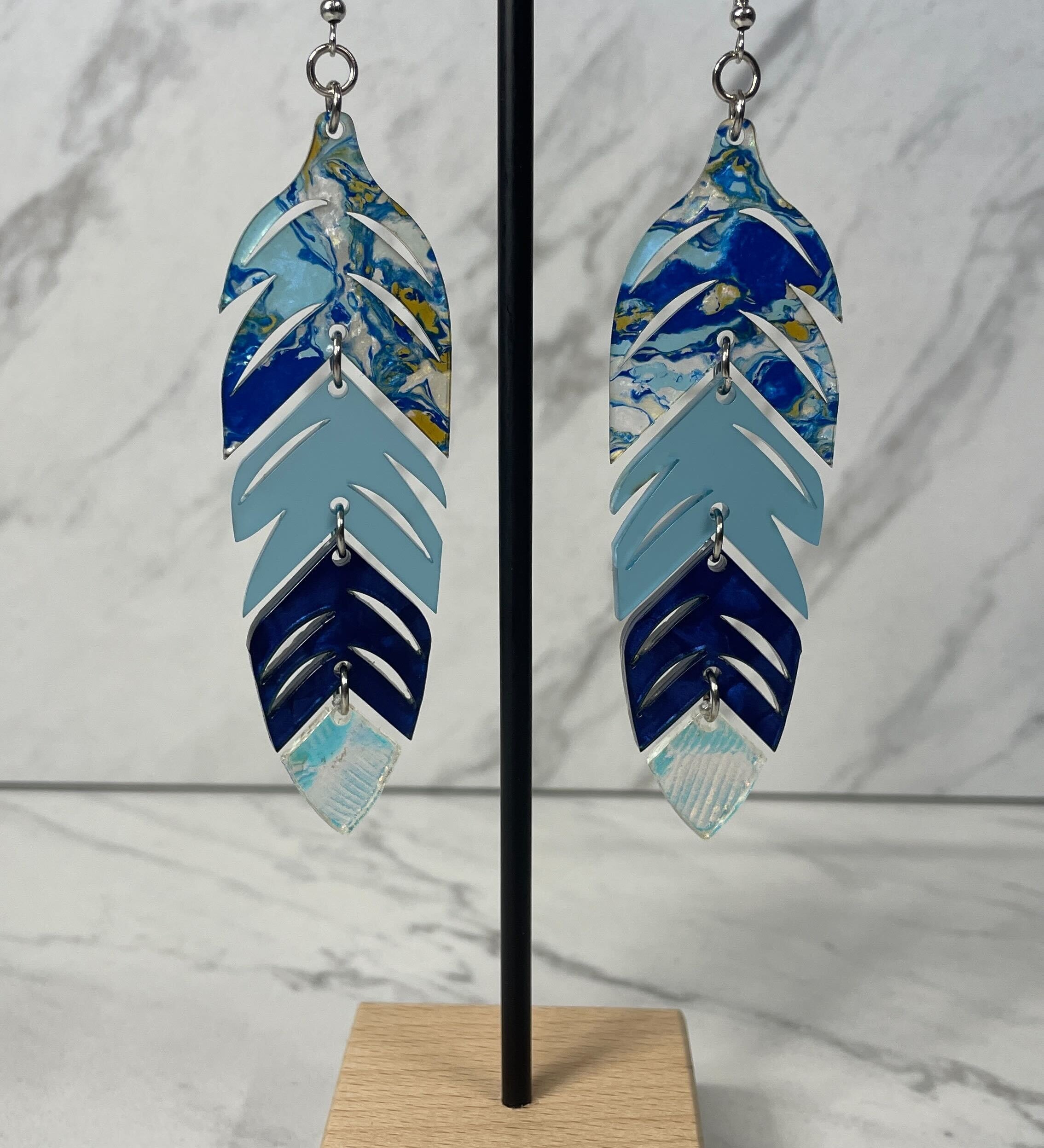 Close up up of dynamic tiered feather earrings by indigenous artist acrylic