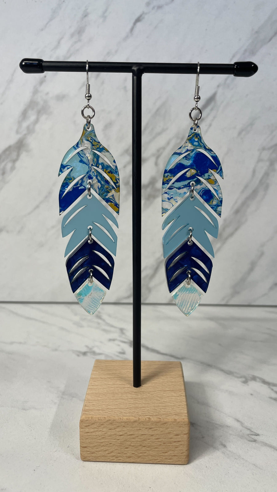 Close up up of dynamic tiered feather earrings by indigenous artist acrylic