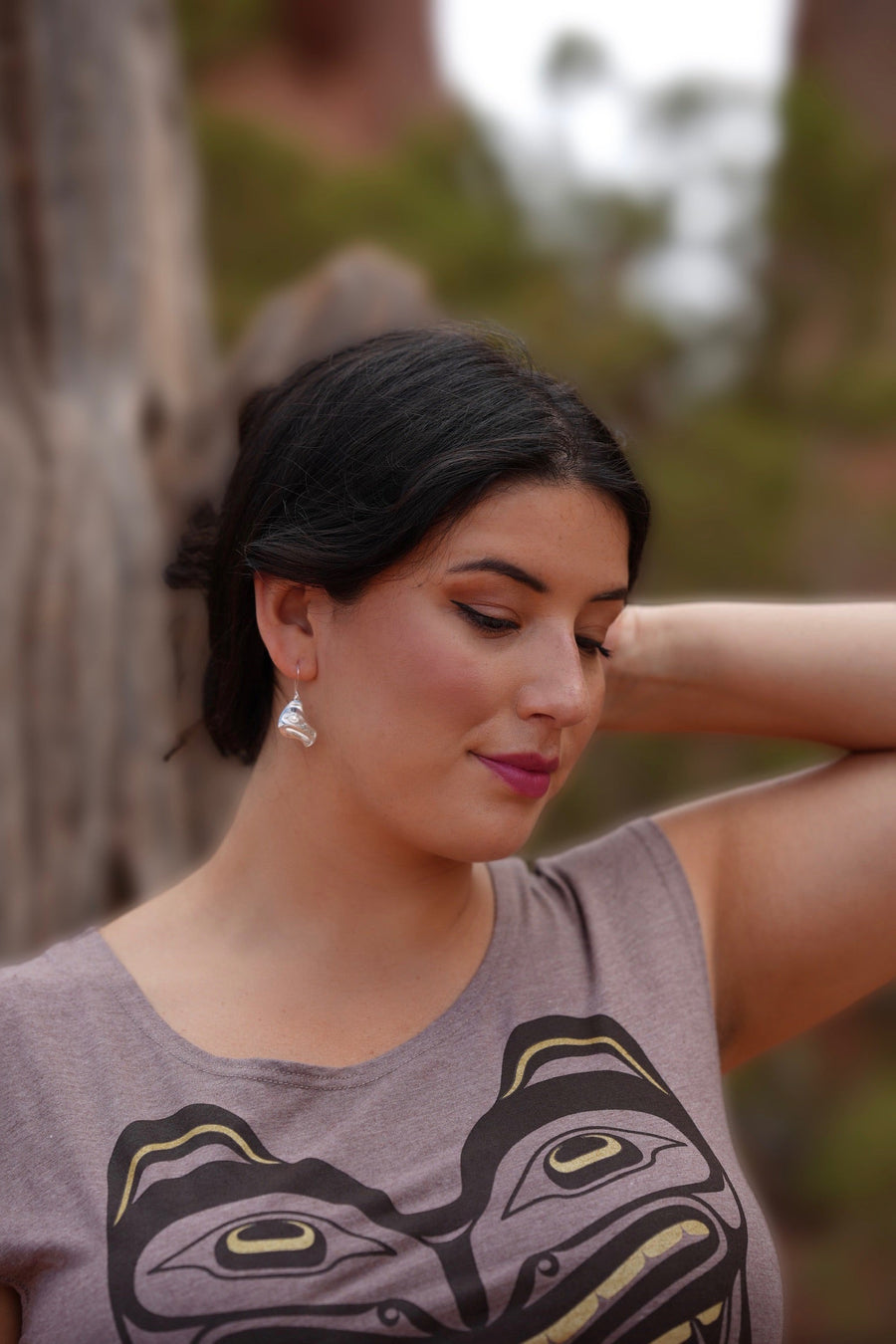 Model wearing earrings silver feather by indigenous artist