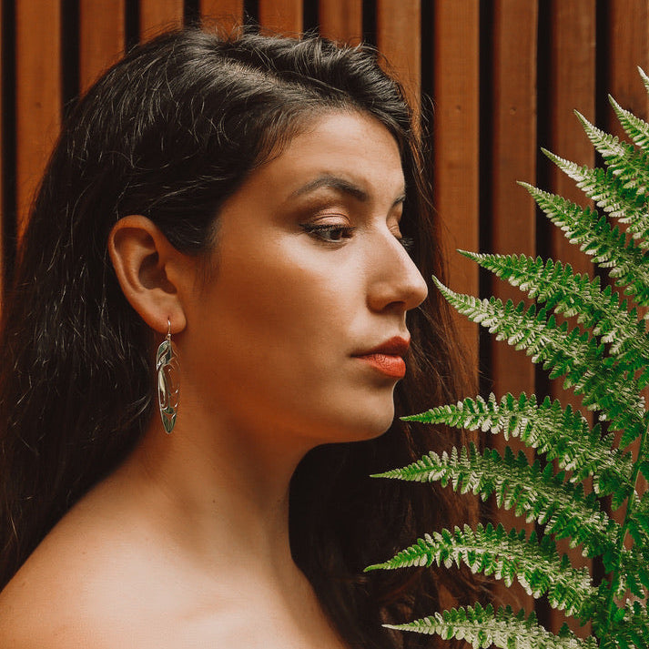 Close up of feather earrings by indigenous artist sterling silver or brass 2
