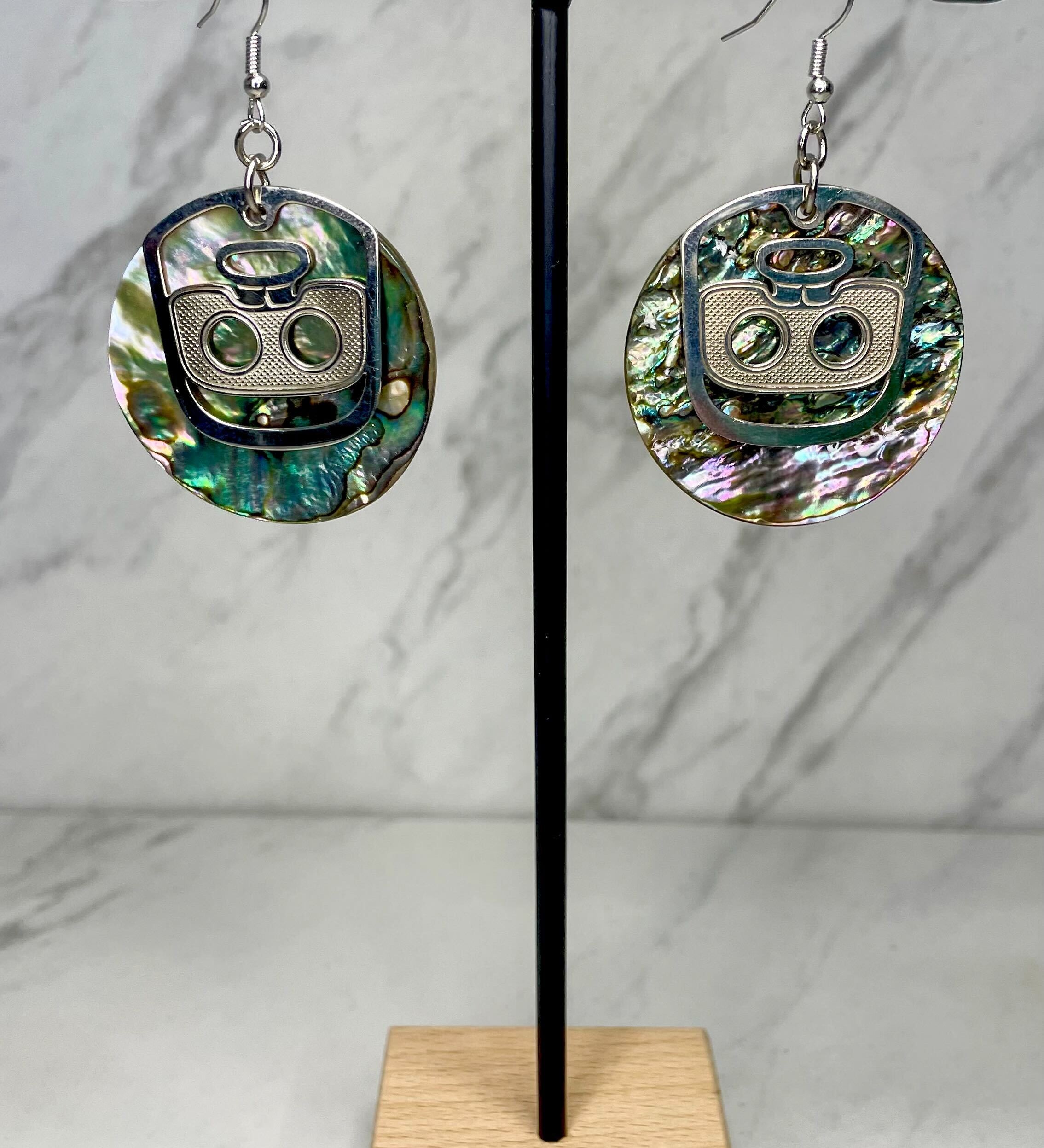 Close up up of ghost face earrings by indigenous artist abalone and silver 2