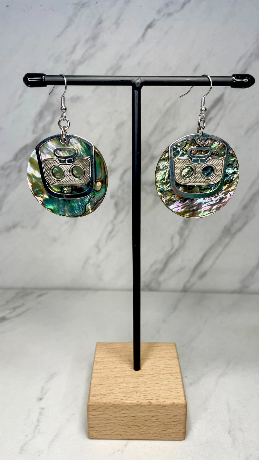 Close up up of ghost face earrings by indigenous artist abalone and silver 2