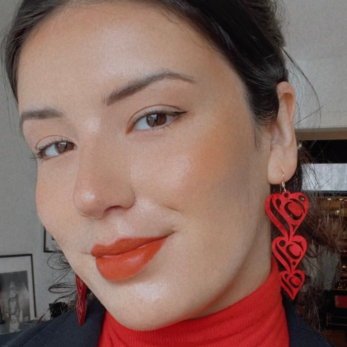Model wearing heart drops earrings by indigenous artist acrylic