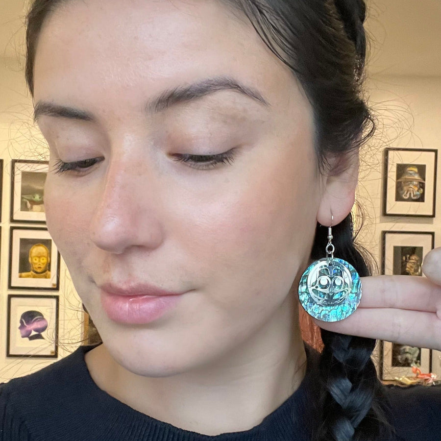 Model wearing mouse woman abalone earrings by indigenous artist silver or brass