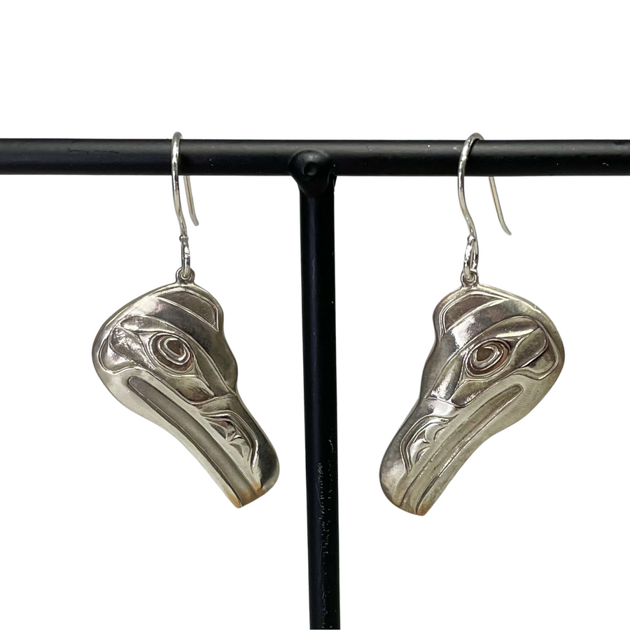Close up of silver raven head earrings by indigenous artist