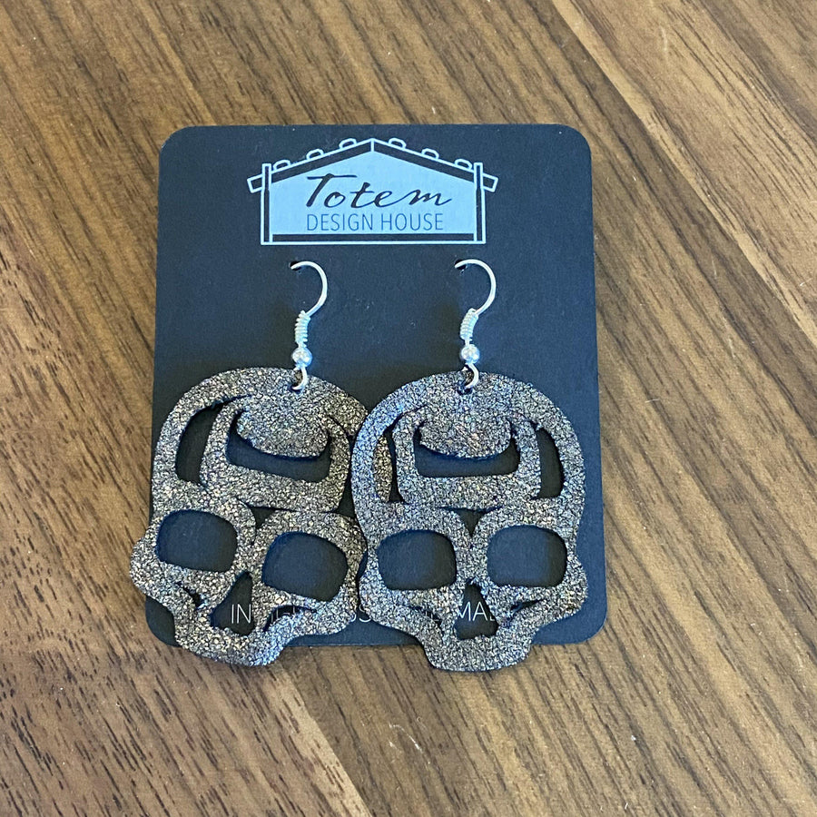 Close up of skull earrings by indigenous artist copper metallic leather 2