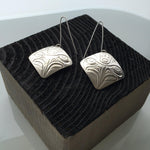 Close up of earrings silver square eagle by indigenous artist in black box