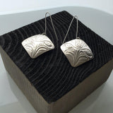 Close up of earrings silver square eagle by indigenous artist in black box