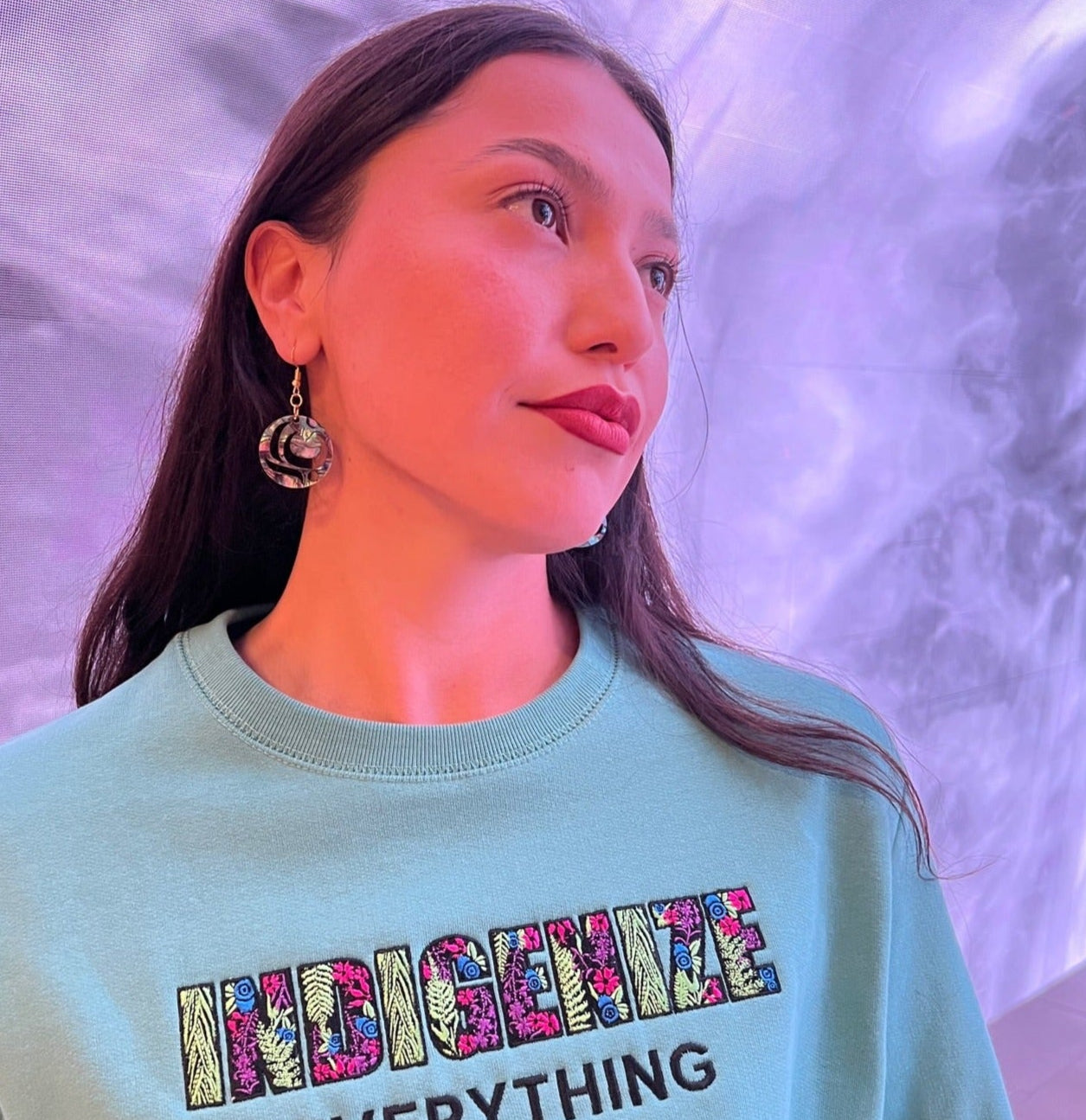 Model wearing salmon trout head earrings by indigenous artist acrylic